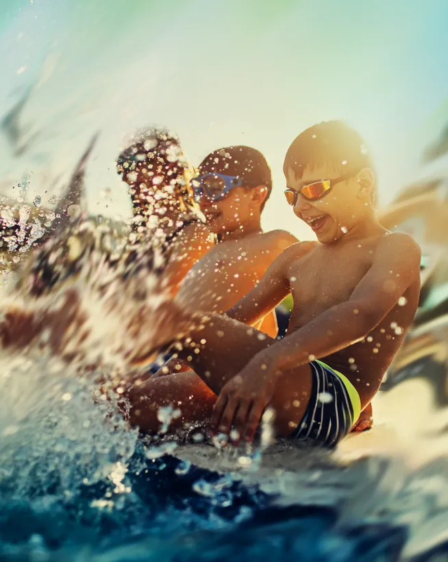 Kinder haben Spaß im Wasser und planschen im Freibad Mirador