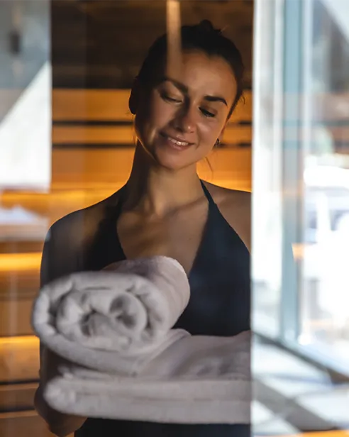 Frau mit Handtüchern im Saunabereich des Mirador