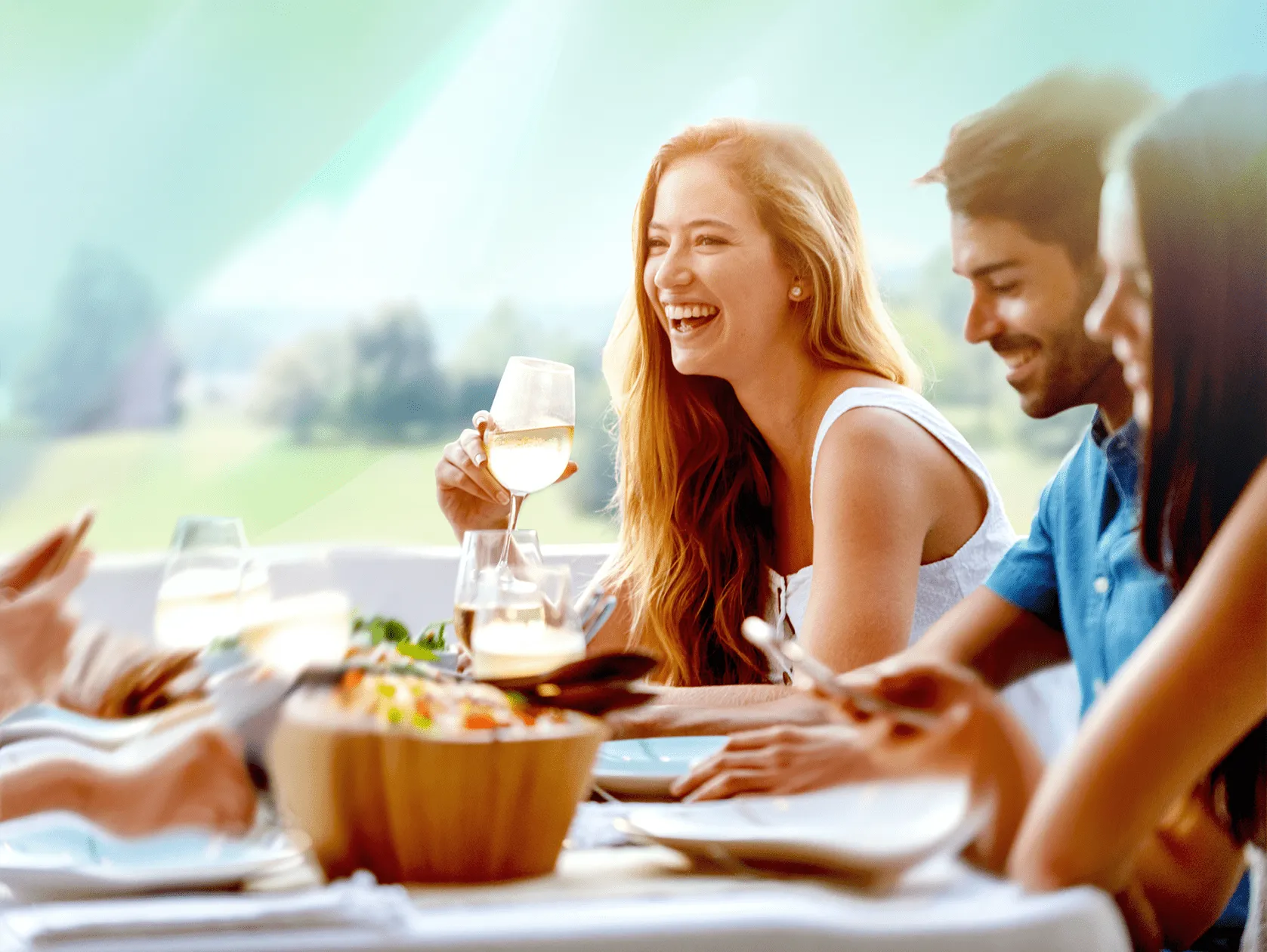 Gäste genießen Essen und Wein auf der Terrasse im Mirador mit Blick ins Grüne