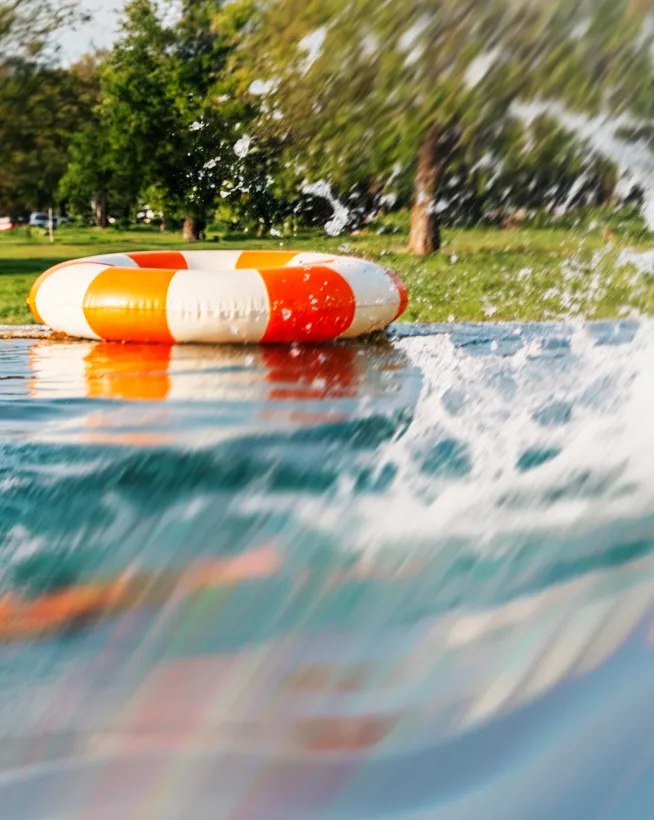 Schwimmreifen am Beckenrand des Freibad Mirador mit Liegewiese